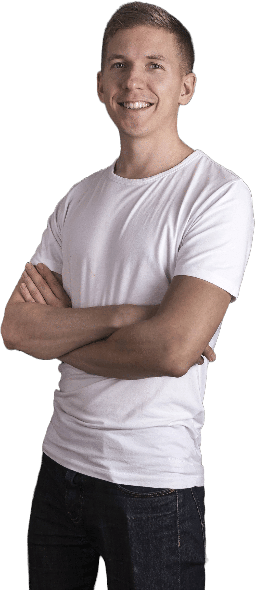 Tapio Kauranen smiling with his arms crossed, in a white T-shirt