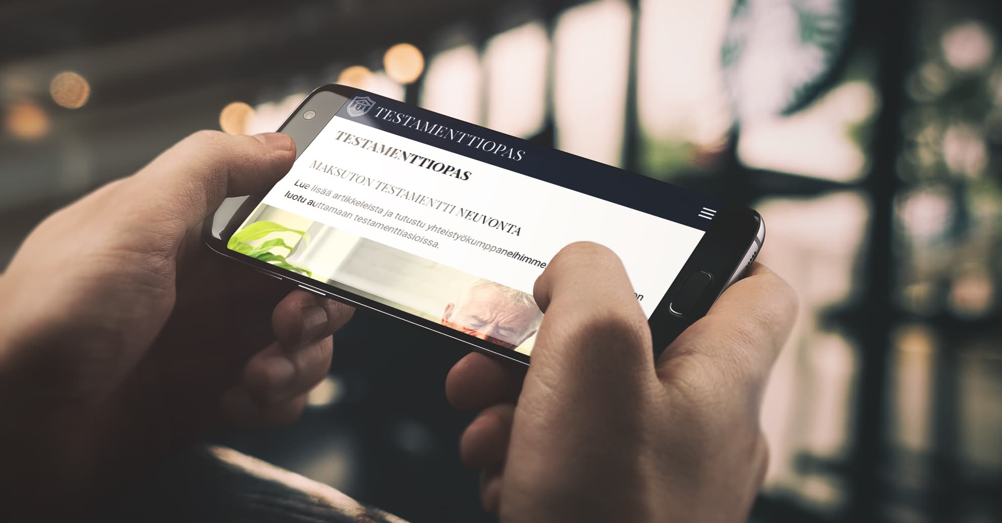 Testamenttiopas-sivusto auki älypuhelimessa: etusivun otsikkona maksuton testamenttineuvonta